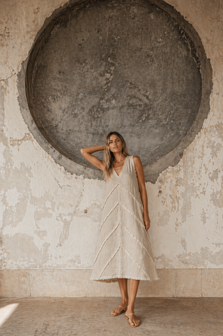 Woman wearing a sky blue chevron linen dress by FABULOUS! Linen in a minimalist Mediterranean setting